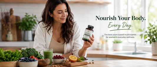 Healthy woman holding plant-based multivitamin supplements in a modern kitchen with natural foods and wellness items