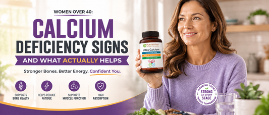 Healthy woman over 40 holding a calcium supplement while smiling in a bright kitchen.
